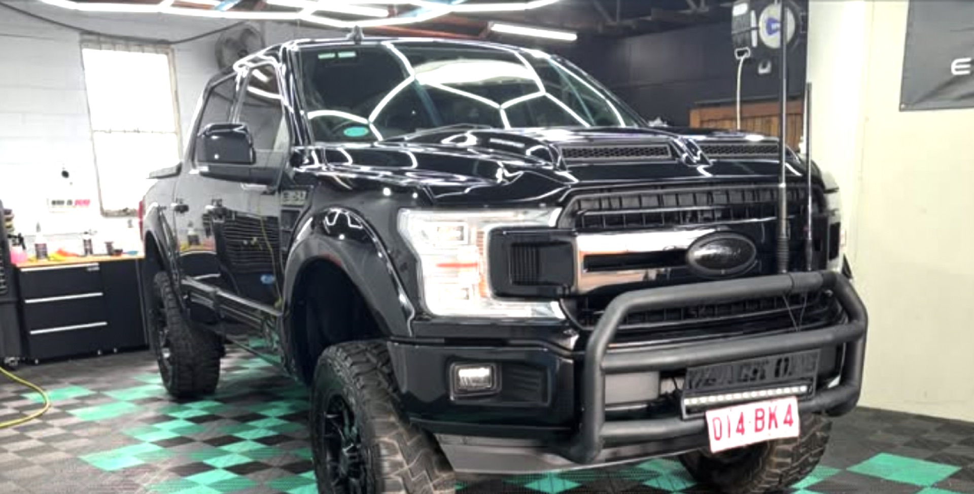 Lifted black Ford F-150 detailed under hex studio lighting